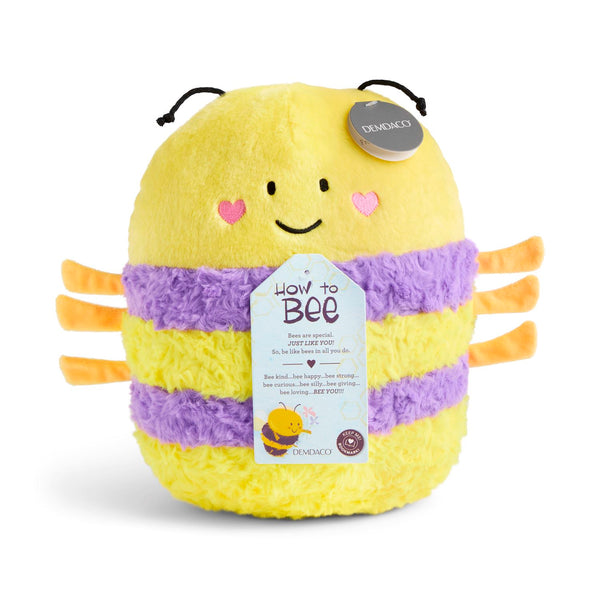 A yellow and purple plush bee toy with orange legs and antennae, featuring a hangtag that reads 'How to Bee' and a circular DEMDACO tag on its head, set against a plain white background.